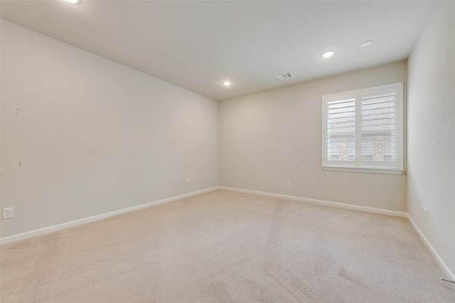 Empty room with light colored carpet, visible vents, recessed lighting, and baseboards | Image 20