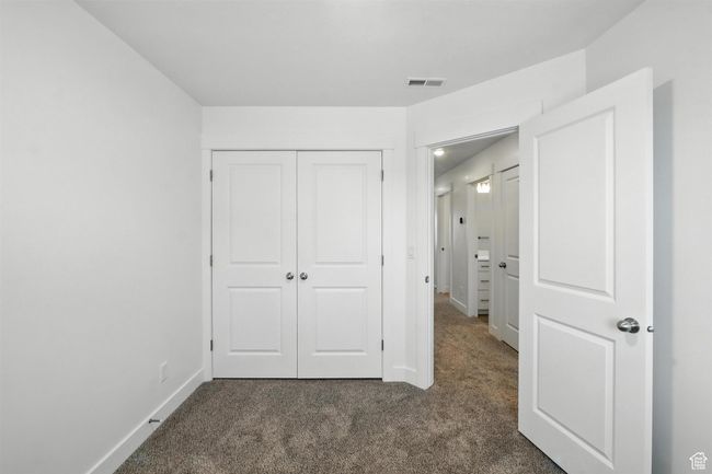 Unfurnished bedroom with dark carpet and a closet | Image 15
