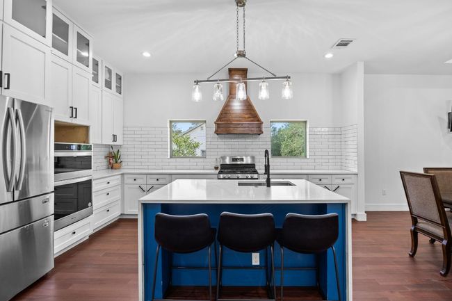 Kitchen with appliances with stainless steel finishes, tasteful backsplash, dark wood-style flooring, light countertops, and recessed lighting | Image 7