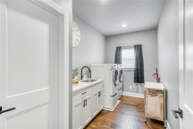 Laundry room with cabinets, separate washer and dryer, sink, and dark hardwood / wood-style flooring | Image 33