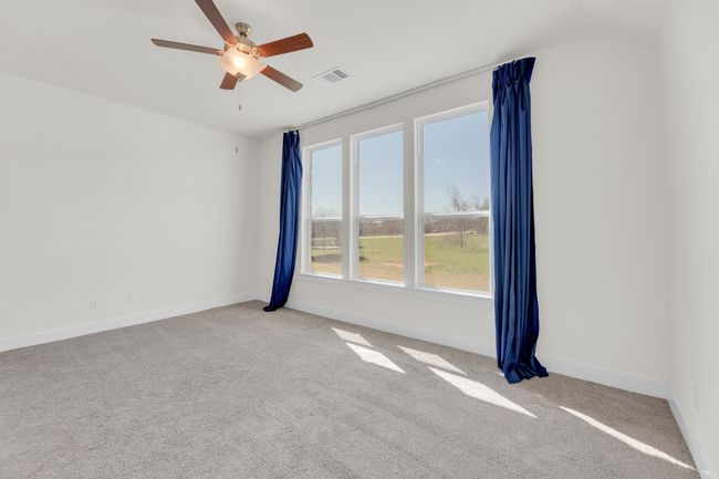 Carpeted empty room featuring visible vents, ceiling fan, and baseboards | Image 20