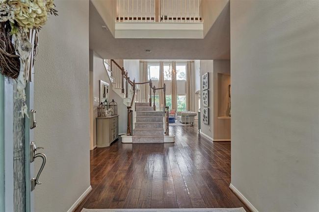 View from front door looking into the home. Beautiful floors are a stand out. 5" custom wood shutters throughout majority of home. | Image 5