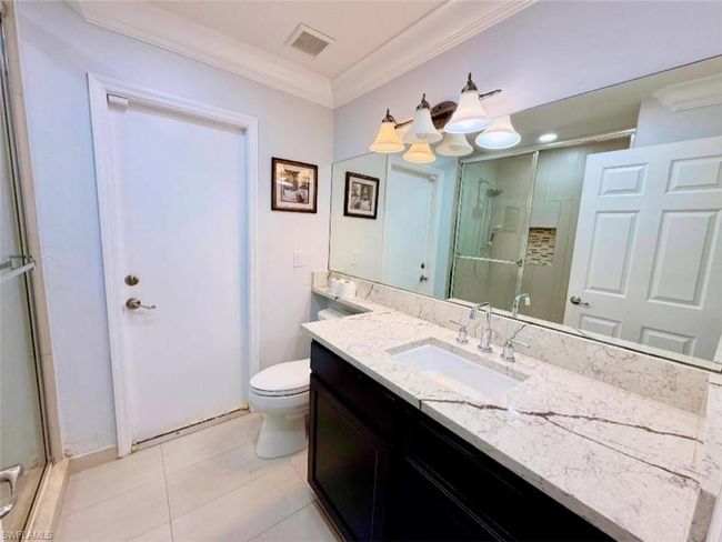 Full bathroom with ornamental molding, toilet, vanity, visible vents, and a stall shower | Image 23
