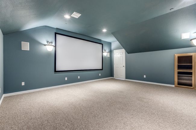 Upstairs is a home theater room just off the Game room with lofted ceiling and baseboards | Image 29