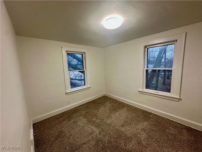 Unfurnished room with dark colored carpet and baseboards | Image 18