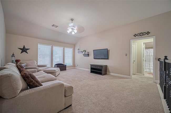 Ascend one of two staircases to discover a massive game room featuring plush carpeting, designer paint, and three large windows that fill the space with abundant natural light. | Image 29