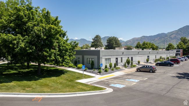 View of building exterior featuring a mountain view and uncovered parking | Image 30