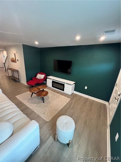 Living room with a fireplace and wood-type flooring | Image 3