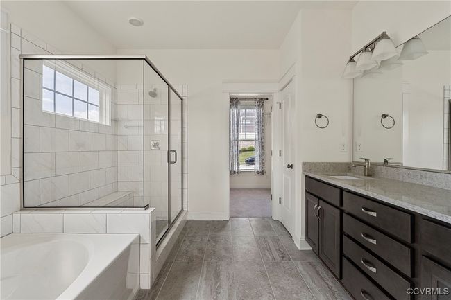 Bathroom featuring a garden tub, vanity, a stall shower, and healthy amount of natural light | Image 30