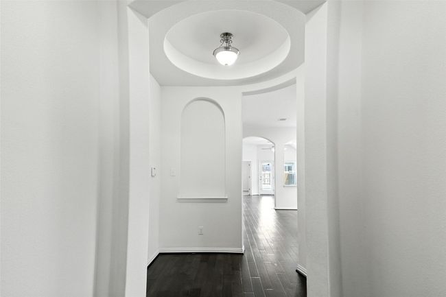 Hall with dark wood finished floors and arched walkways | Image 7