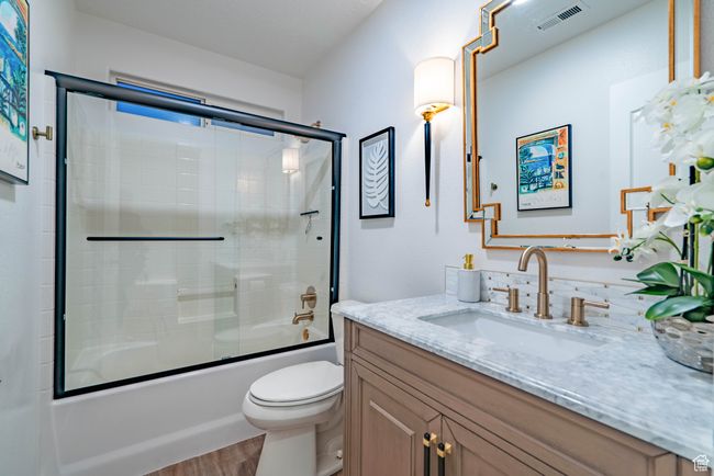Full bathroom with toilet, enclosed tub / shower combo, hardwood / wood-style flooring, and vanity | Image 11