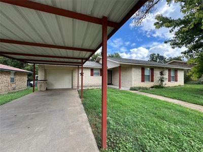 View of front of property featuring a garage, a front lawn, and a carport | Image 1