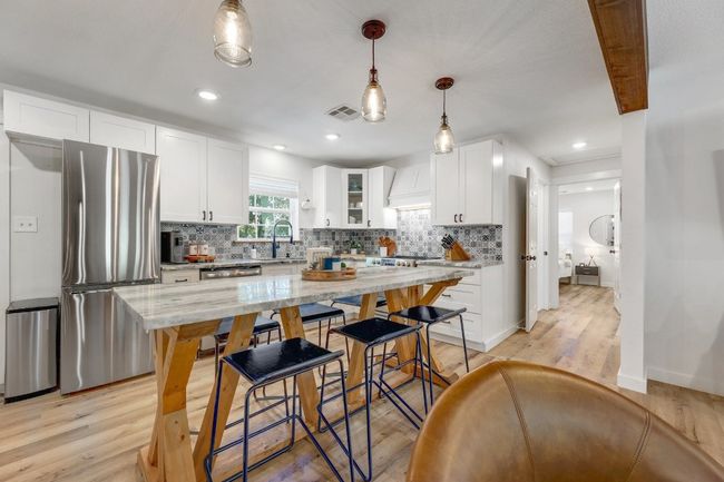 Charming kitchen with custom built-in kitchen island that doubles as table. | Image 5