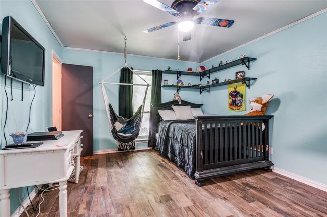 Bedroom with ornamental molding and wood finished floors and swing | Image 17