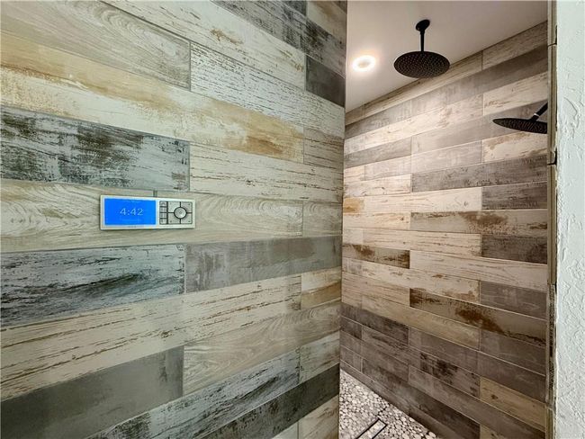 Full bath with tiled shower walls features rain shower heads | Image 28