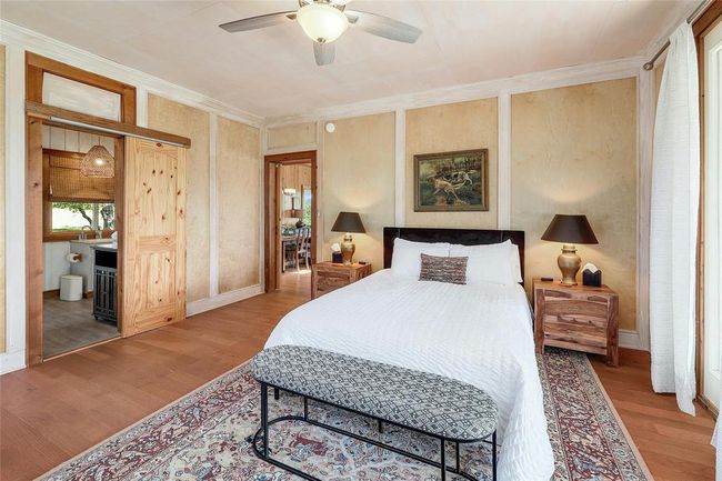Bedroom featuring ensuite bath, a ceiling fan, wood finished floors, and ornamental molding | Image 19