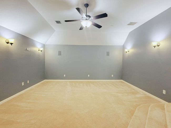 Unfurnished room with a ceiling fan, carpet floors, and lofted ceiling | Image 27