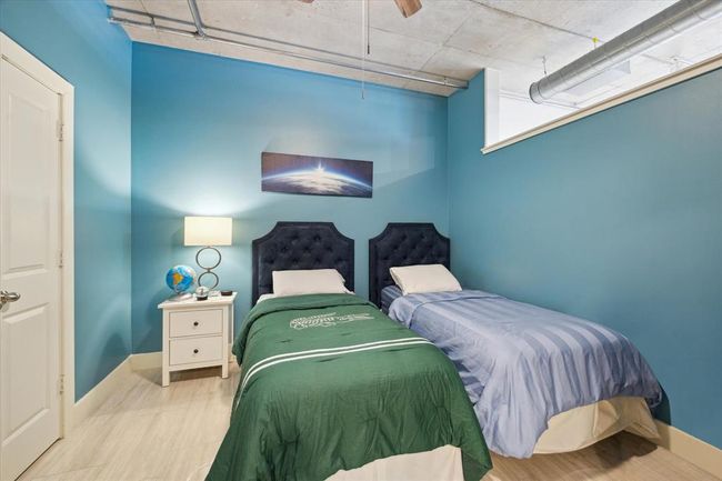 The secondary bedroom (approx. 11x11) features elegant tile flooring, natural lighting, and a spacious walk-in closet. | Image 13