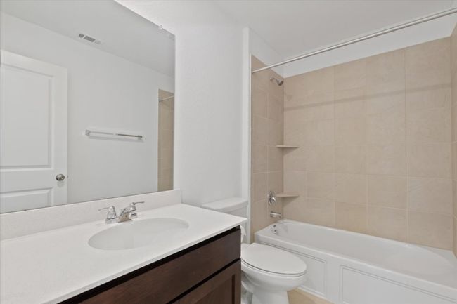 Bathroom with toilet, visible vents, vanity, and washtub / shower combination | Image 17