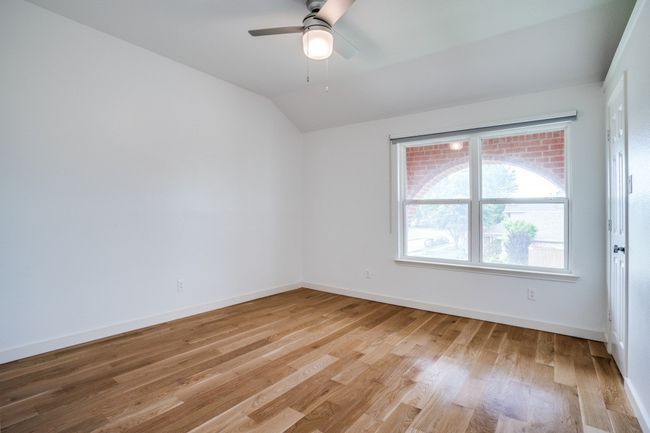 Empty room featuring lofted ceiling, light wood-style floors, baseboards, and ceiling fan | Image 20