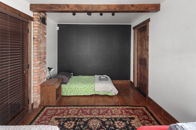 Bedroom featuring wood finished floors and beamed ceiling | Image 22