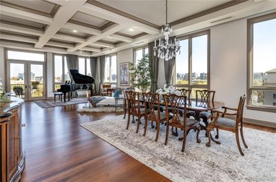 Gorgeous dining space featuring high coffered ceilings, large windows with views and hardwood floors. | Image 2