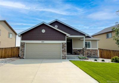 Craftsman-style home featuring a 2-car garage and a manicured front yard | Image 1