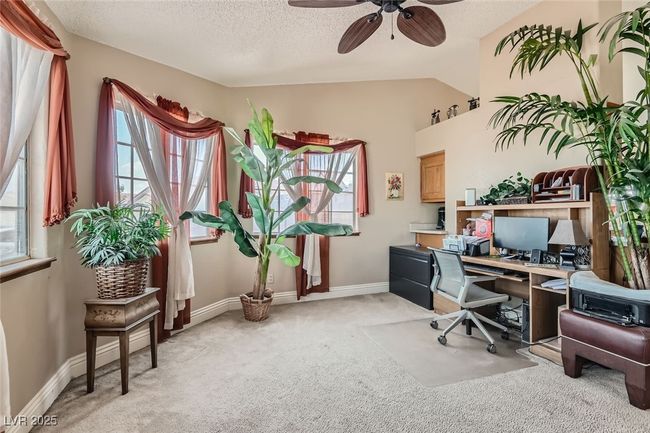 Office space with light carpet, baseboards, ceiling fan, vaulted ceiling, and a textured ceiling | Image 6