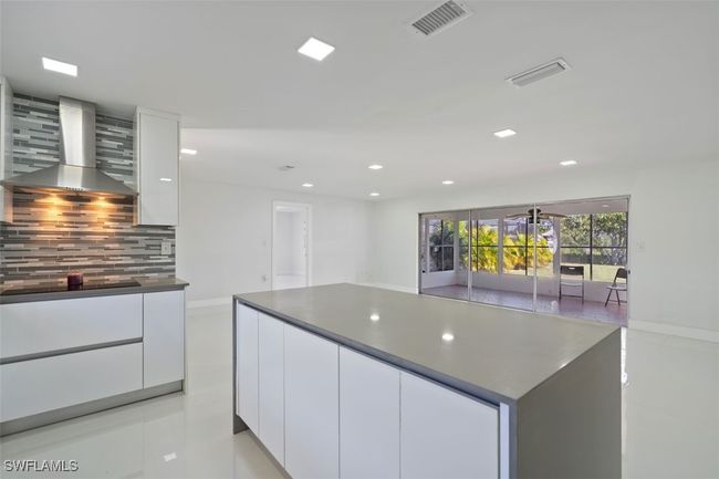 Kitchen featuring white cabinetry, modern cabinets, and wall chimney range hood | Image 9