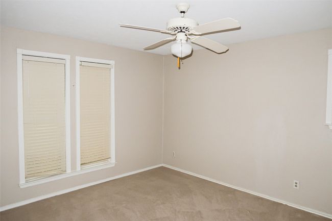 Carpeted empty room featuring ceiling fan and baseboards | Image 36