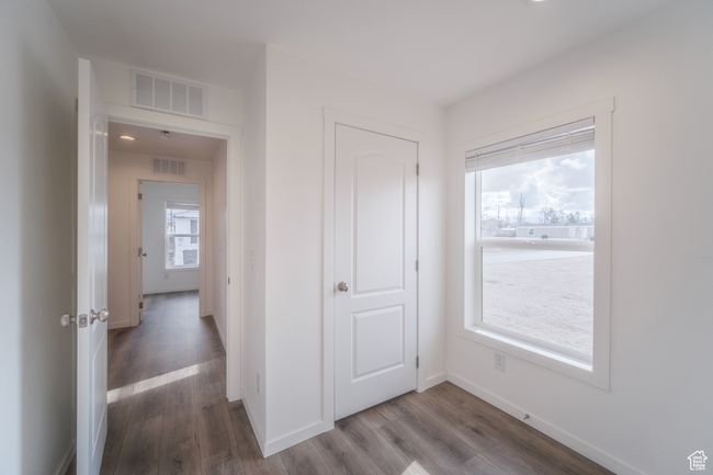 Hallway featuring visible vents, baseboards, and wood finished floors | Image 15