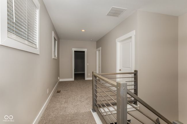 hall featuring recessed lighting, visible vents, an upstairs landing, baseboards, and light colored carpet | Image 10