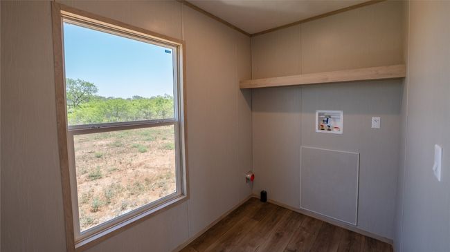 Washroom featuring hookup for a washing machine, wood finished floors, and crown molding | Image 27