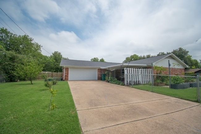 Single story home with brick siding, driveway, and an attached garage | Image 17