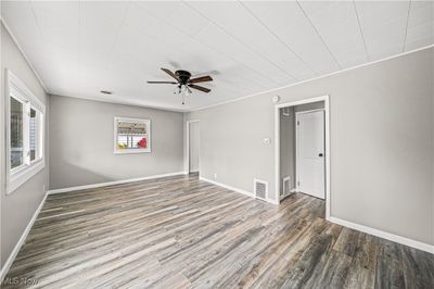 Empty room with ceiling fan and dark hardwood / wood-style flooring | Image 3