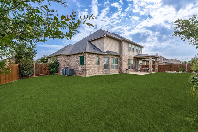 Rear view of house featuring a patio, a fenced backyard, brick siding, and roof with shingles | Image 25