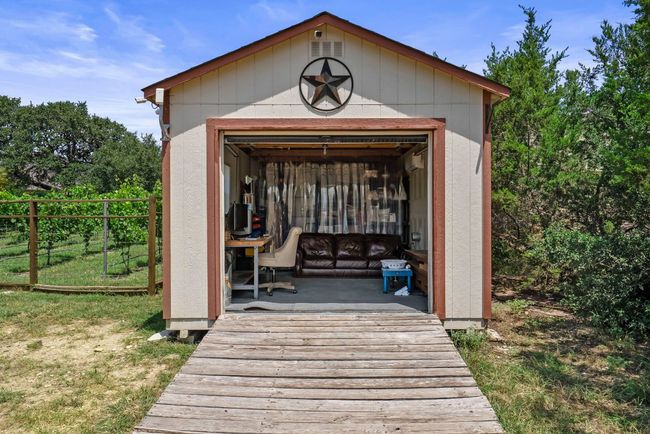 The detached insulated workshop is a versatile space for any passion, featuring, electricity, and an AC minisplit unit, front & rear doors | Image 33