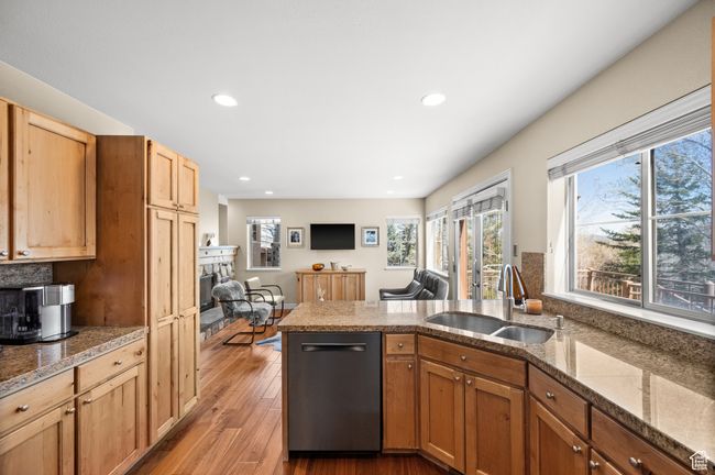 Kitchen featuring dishwasher, a fireplace, a sink, light wood-style floors, and a peninsula | Image 11