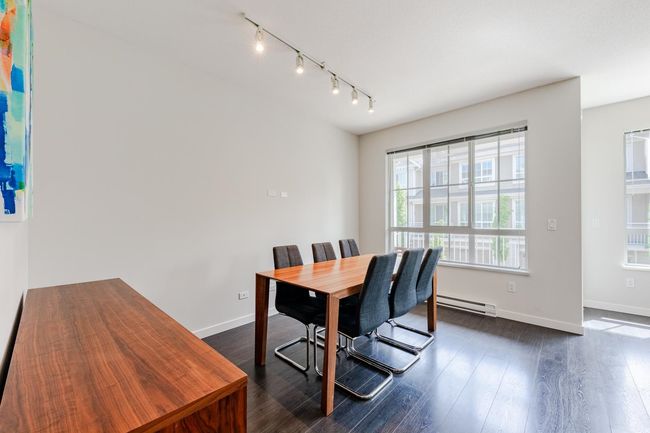 Dining room featuring baseboard heating, dark wood-type flooring, and rail lighting | Image 6