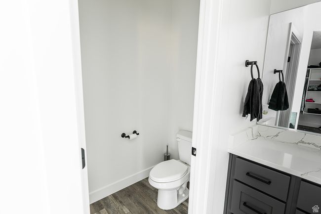 Bathroom featuring toilet, vanity, wood finished floors, and baseboards | Image 14