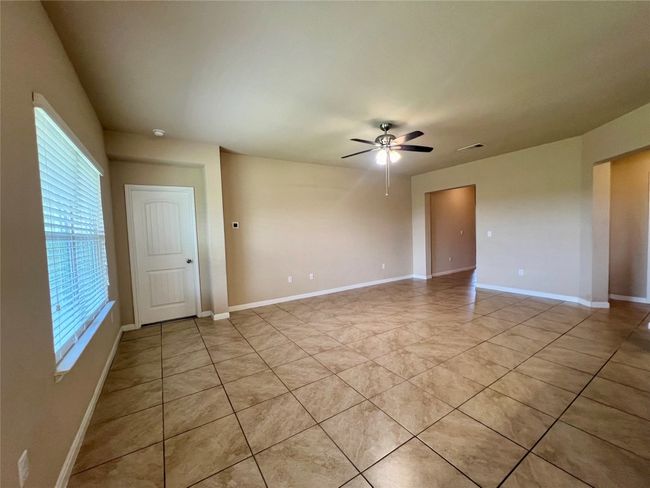 Family room with a ceiling fan, light tile patterned floors, and baseboards | Image 22