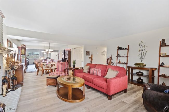 Living area with a notable chandelier and light wood-style flooring | Image 14