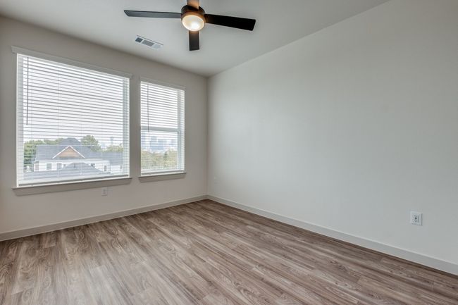 Empty room with light wood finished floors, visible vents, a ceiling fan, and baseboards | Image 14