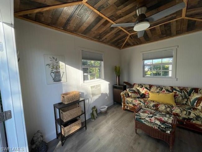 Living room featuring lofted ceiling, crown molding, ceiling fan, wood-type flooring, and wood ceiling | Image 11