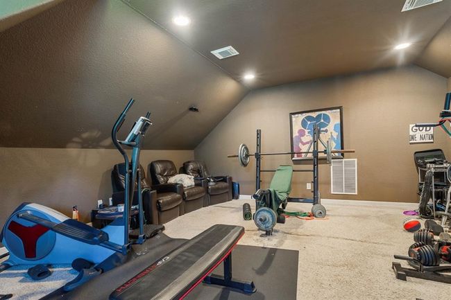 Upstairs media room is currently being used as a fitness center. Three recliners and projector stays with home. | Image 25