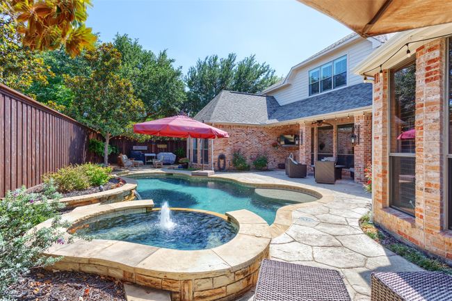View of pool featuring a patio area, a fenced backyard, an outdoor hangout area, and a pool with connected hot tub | Image 32