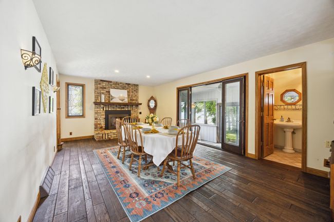 This is the dining room/ family room with a gas fireplace. Leads to the 4 season porch also overlooking the lake. With half bath on the main level. | Image 6