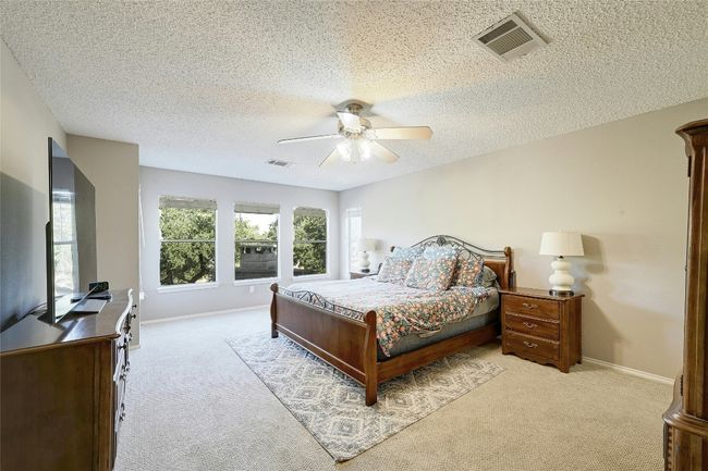 Bedroom featuring carpet, a textured ceiling, and a ceiling fan | Image 19