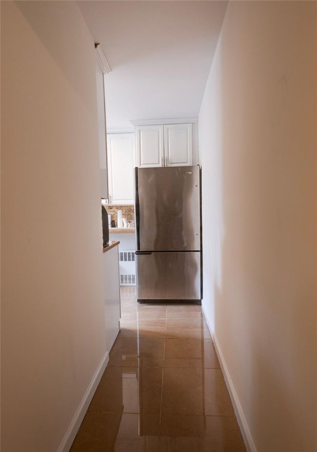 Hall with light tile patterned floors and baseboards | Image 7