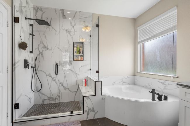 Full bath with a garden tub, a marble finish shower, and plenty of natural light | Image 23